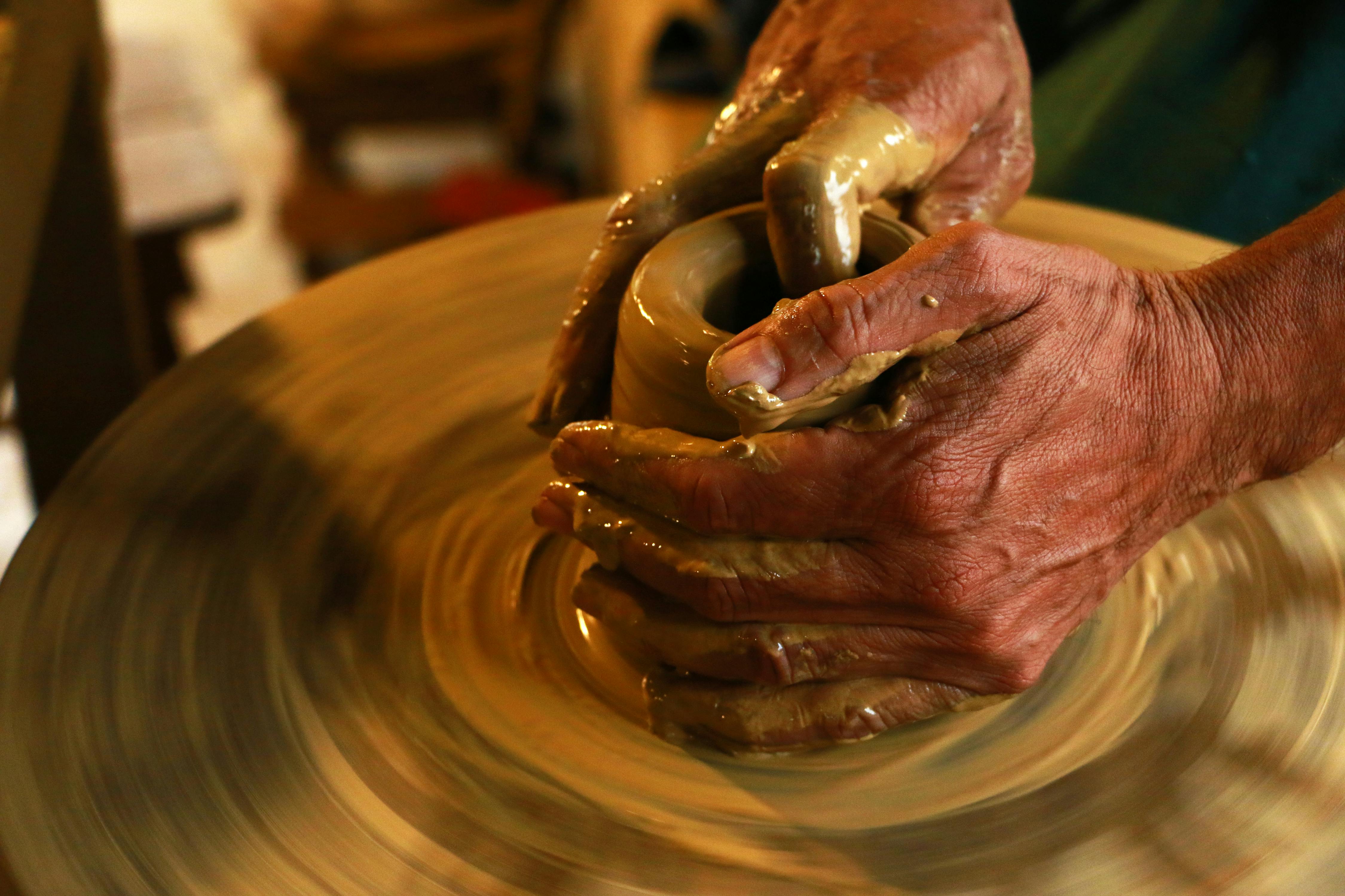 Person making pottery on the wheel